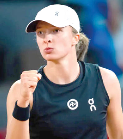 Iga Swiatek in action during a tennis match.