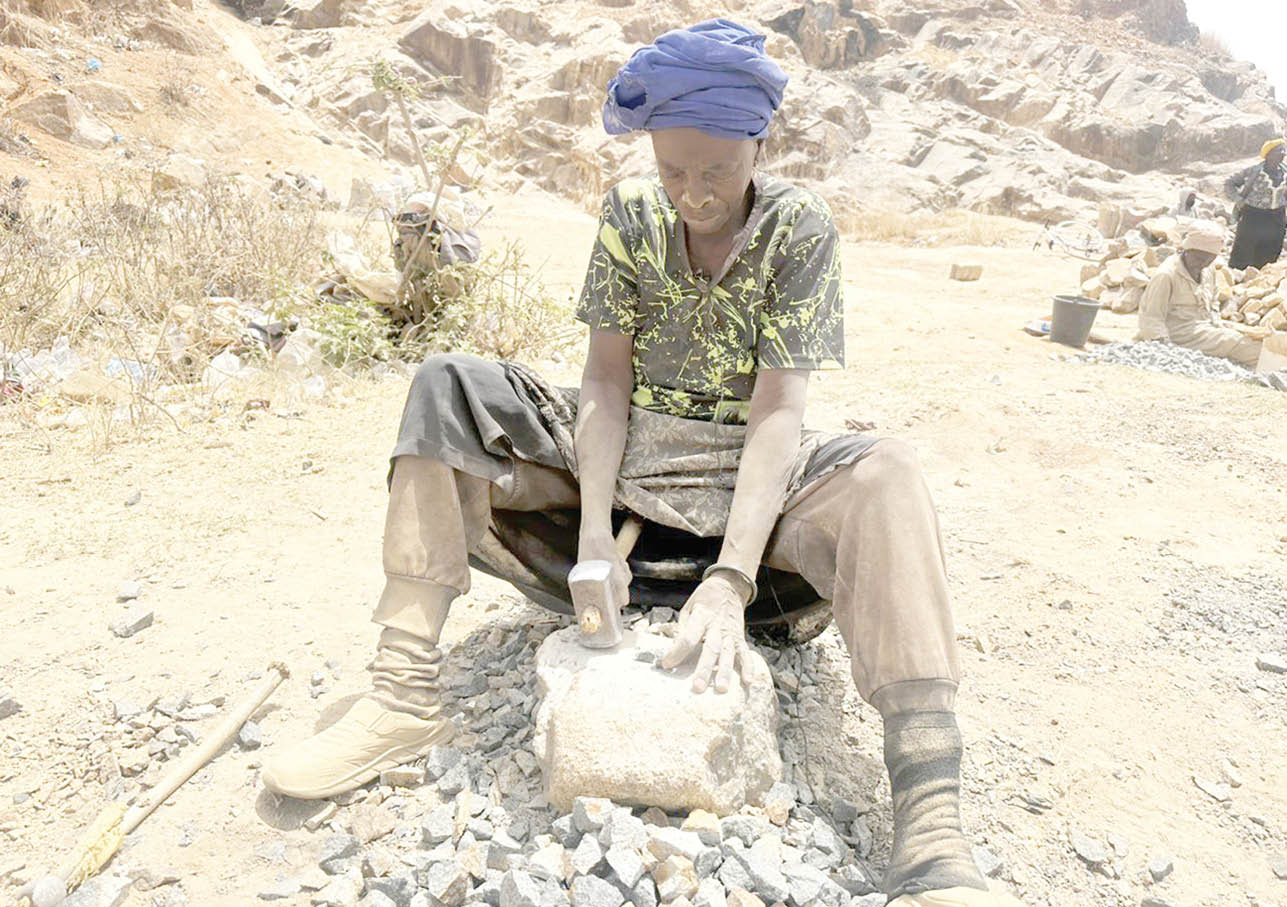 Elderly Jos widows crushing stones for survival