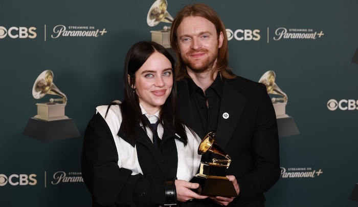 Billie Eilish accepting an award on stage at the Grammy Awards.