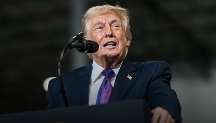 US President Donald Trump speaking at a podium.