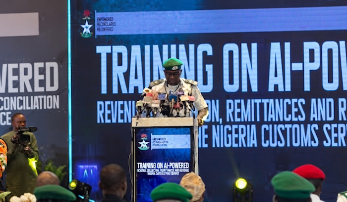 Nigeria Customs Service officers in uniform standing near a banner indicating the deployment of AI technology.