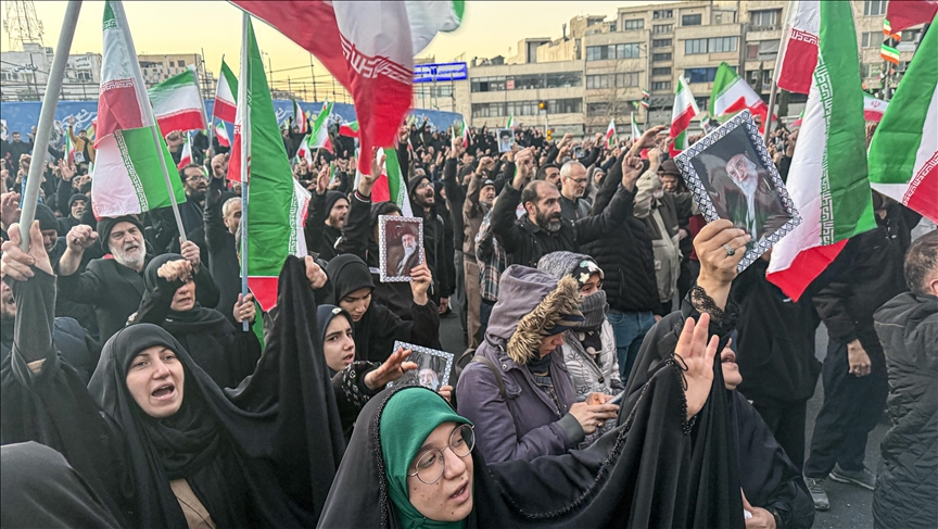 Thousands of Iranians gathered for a mourning rally, holding portraits and flags.