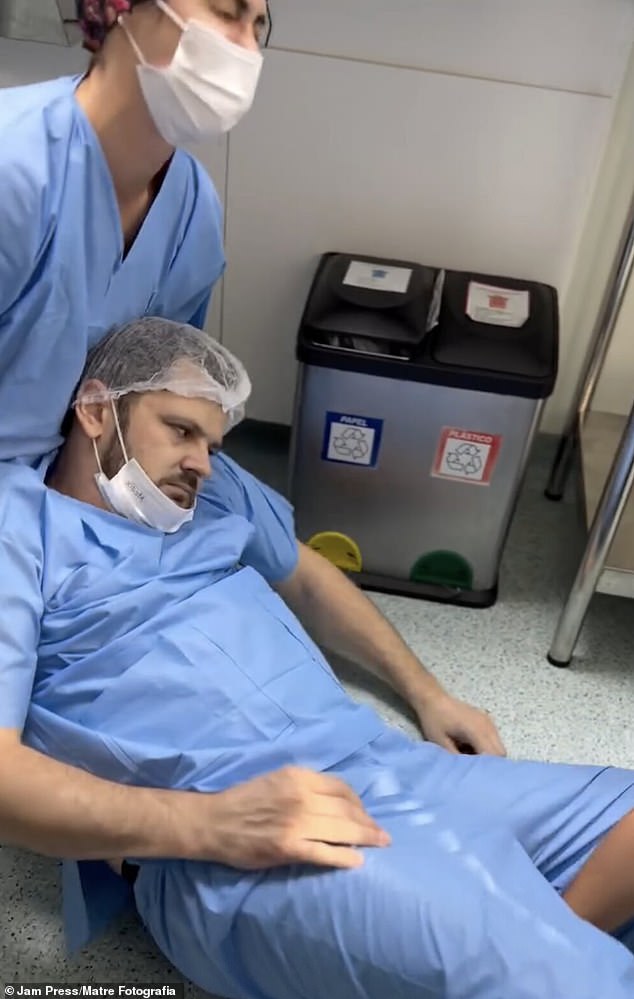 Medical staff attend to a man who has fainted in the delivery room.