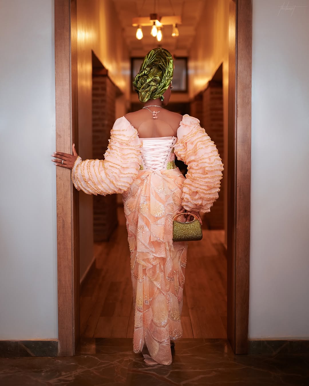Back view of the peach Yoruba bridal dress with detachable skirt overlay