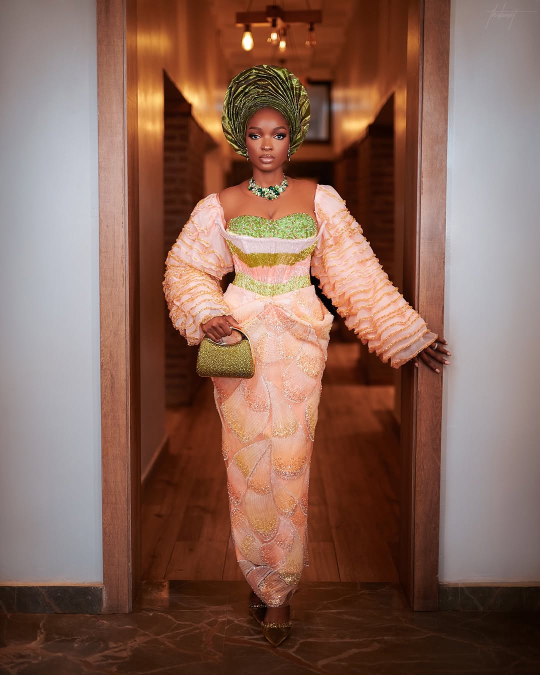 Yoruba bride showcasing the volume of the ruffled sleeves on her peach wedding dress