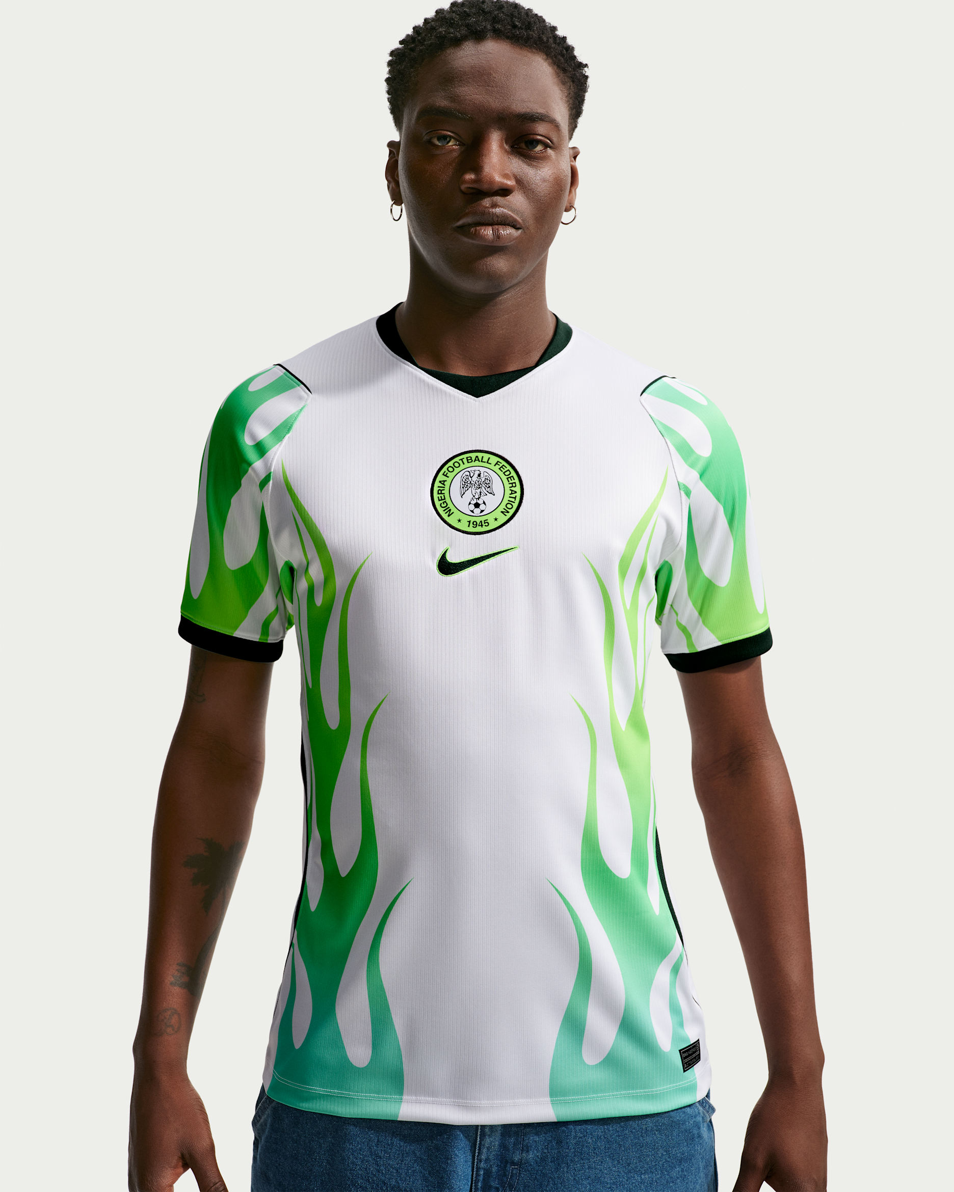 A male model in the 2026 Nike Super Eagles away jersey, featuring a white base with green flame patterns.