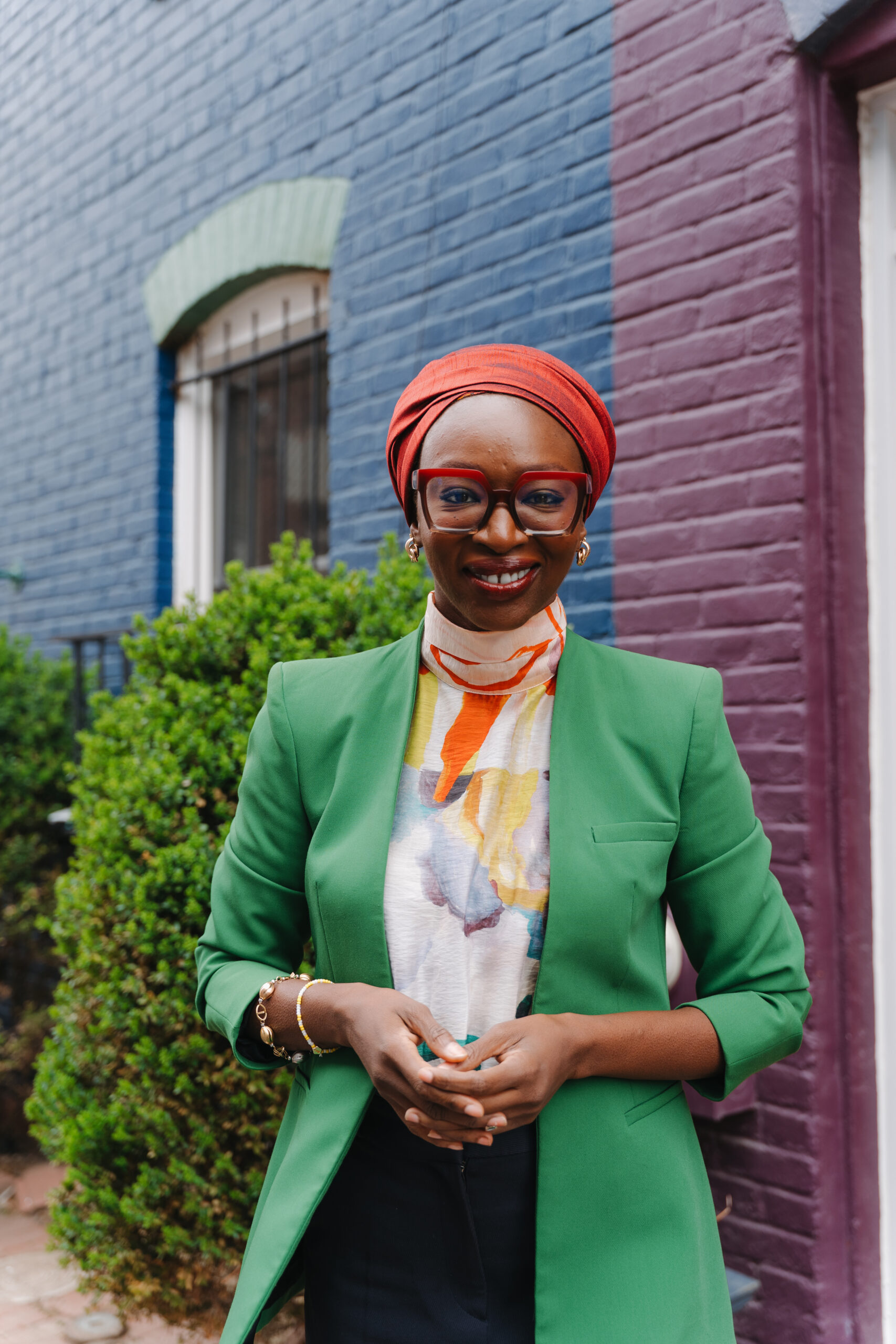 A professional portrait of Nabila Aguele, the newly appointed Global CEO of Malala Fund, wearing a green blazer and red headwrap.