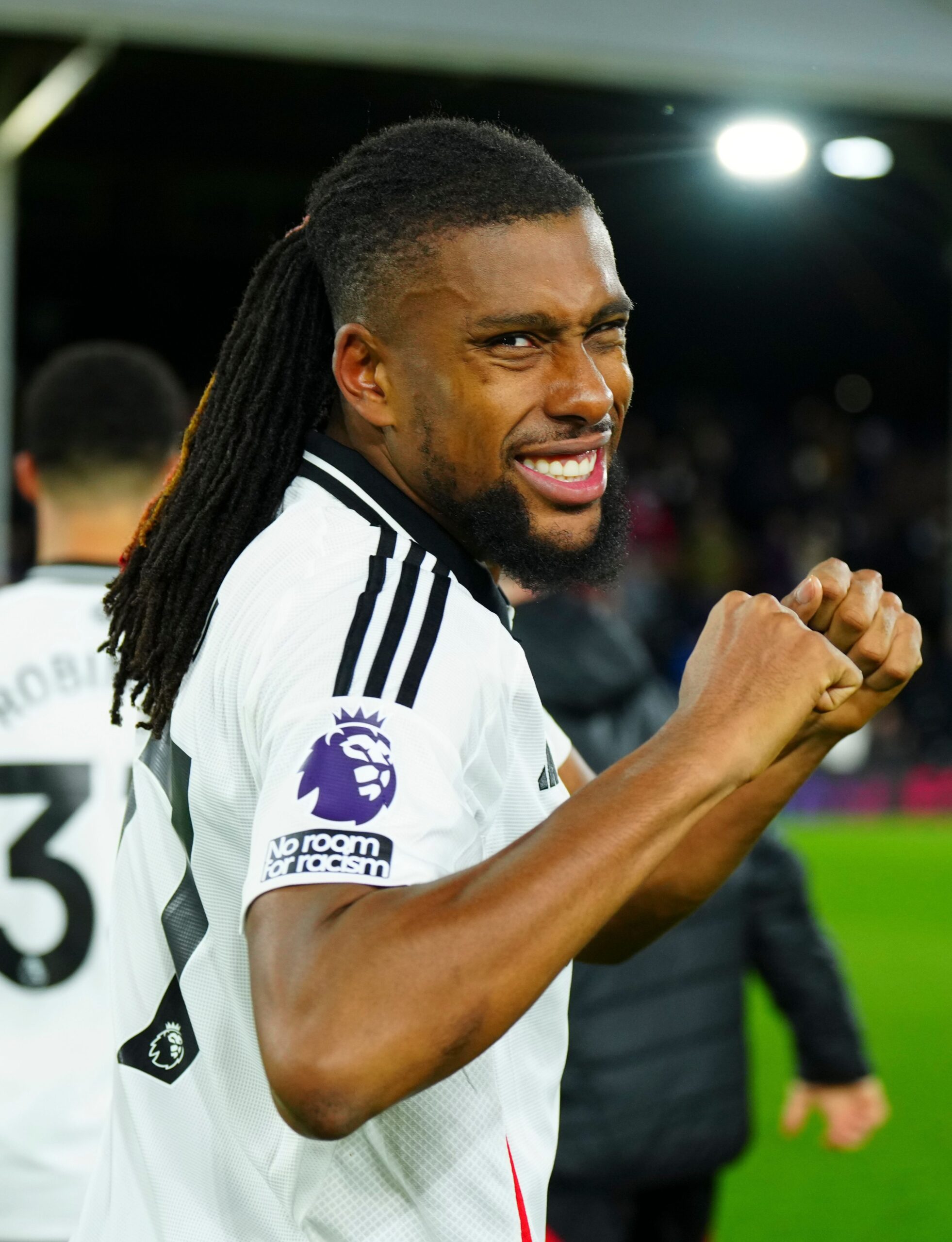 Alex Iwobi in a Fulham FC jersey, smiling after a match.