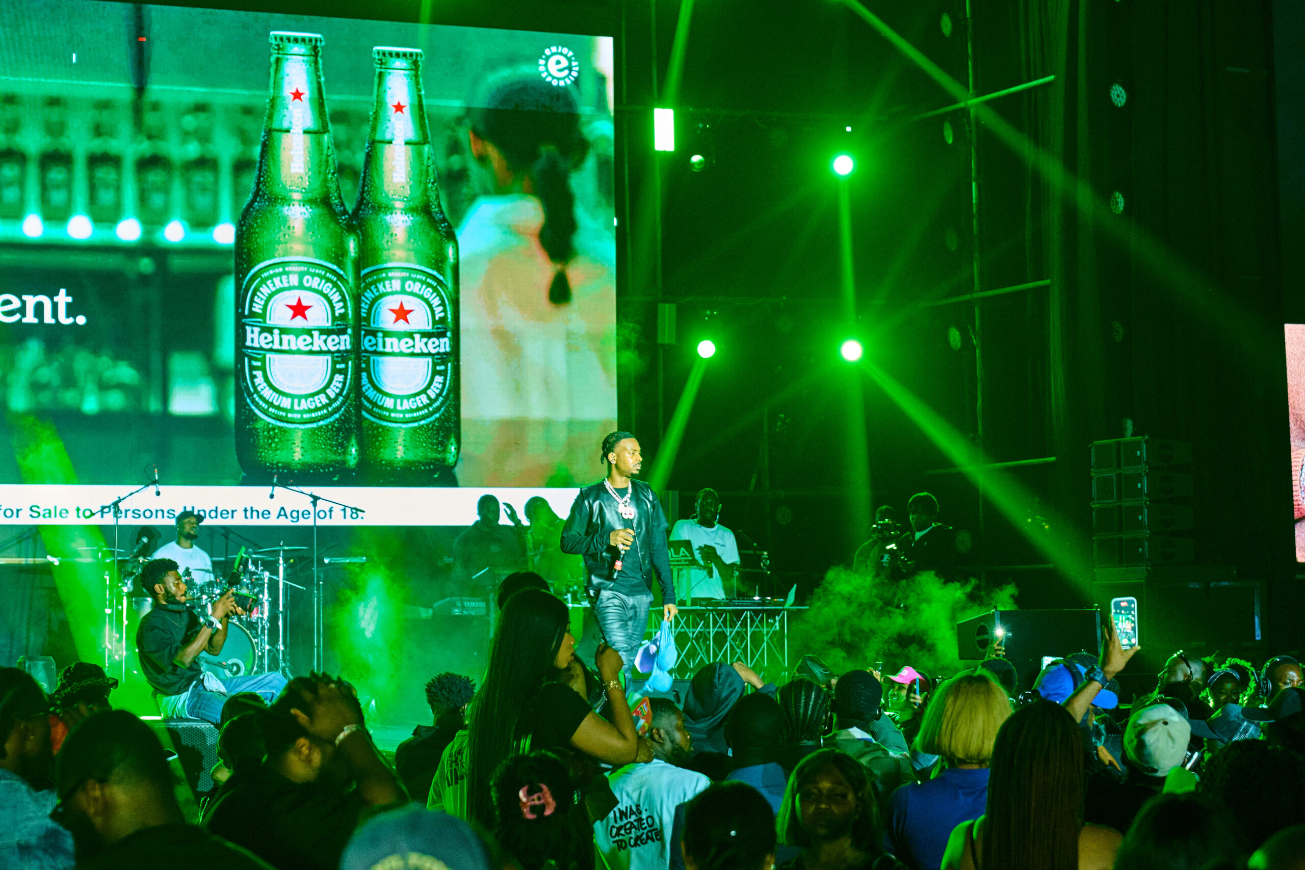 Young Jonn performing on stage with energetic lighting during the Heineken concert in Abuja.