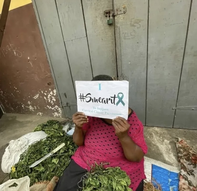 A woman smears lipstick on her face as part of the #SMEARIT campaign for cervical cancer awareness.