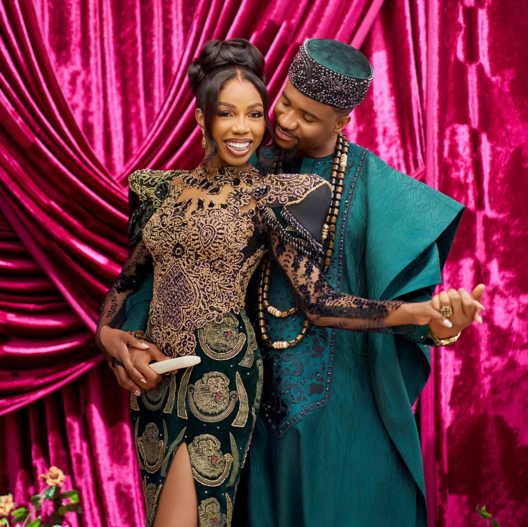 Nollywood actor Jide Kene Achufusi in an emerald green Agbada and his bride Ifeoma in a black and gold sculptural Isi-Agu gown during their Igba Nkwu ceremony.