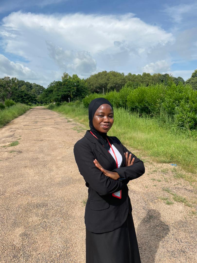 Fareedah Adeowu smiling in a graduation gown or academic attire.