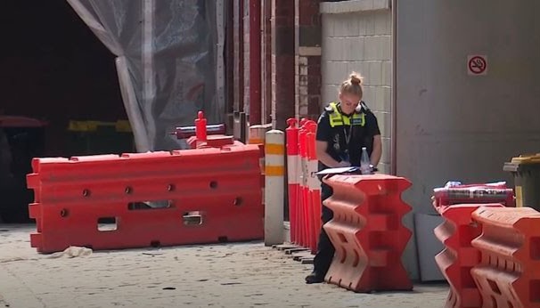 Emergency responders at the scene where a pedestrian was injured after a woman fell from a building in Melbourne.