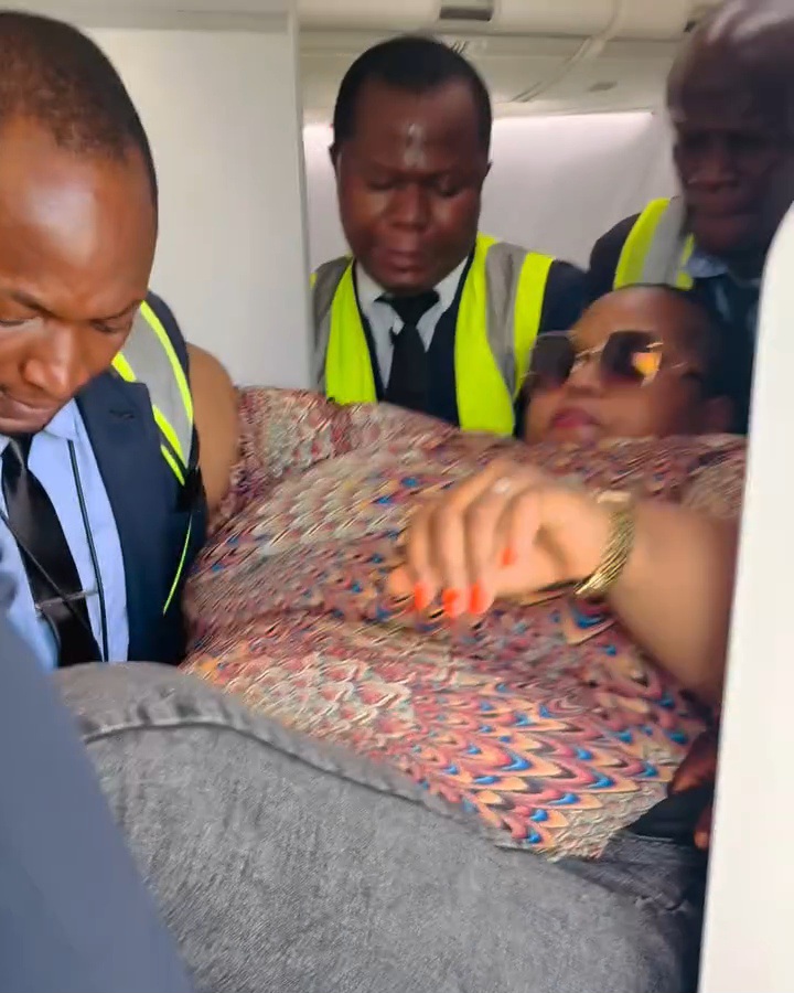 Dorathy Osaronu being assisted by airline staff to exit the plane