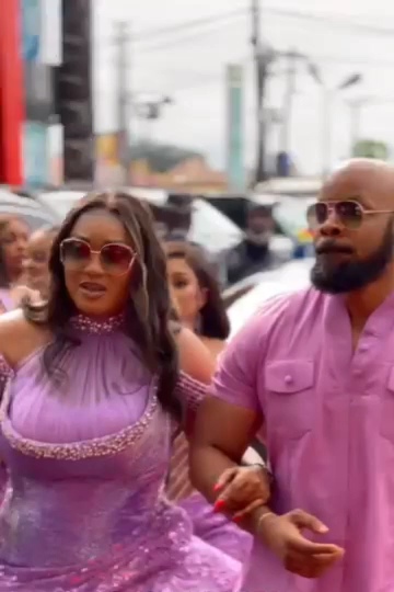 Peggy Ovire walking on the arm of Kachi Nnochiri at the event