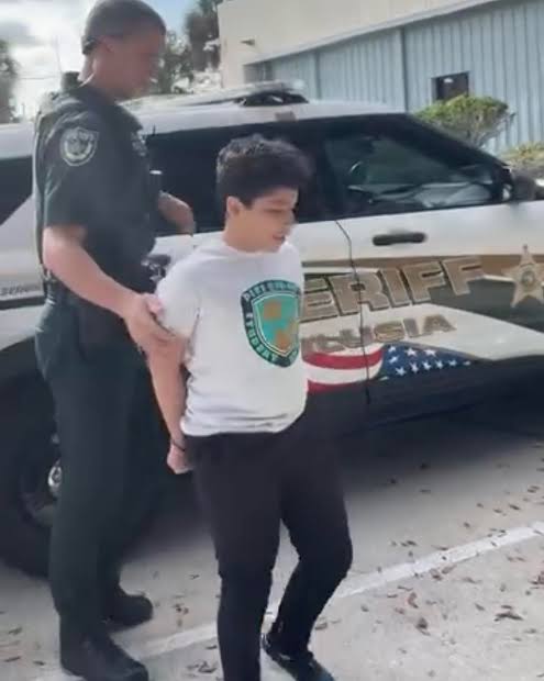 10-year-old boy being escorted by police after making threats at school.